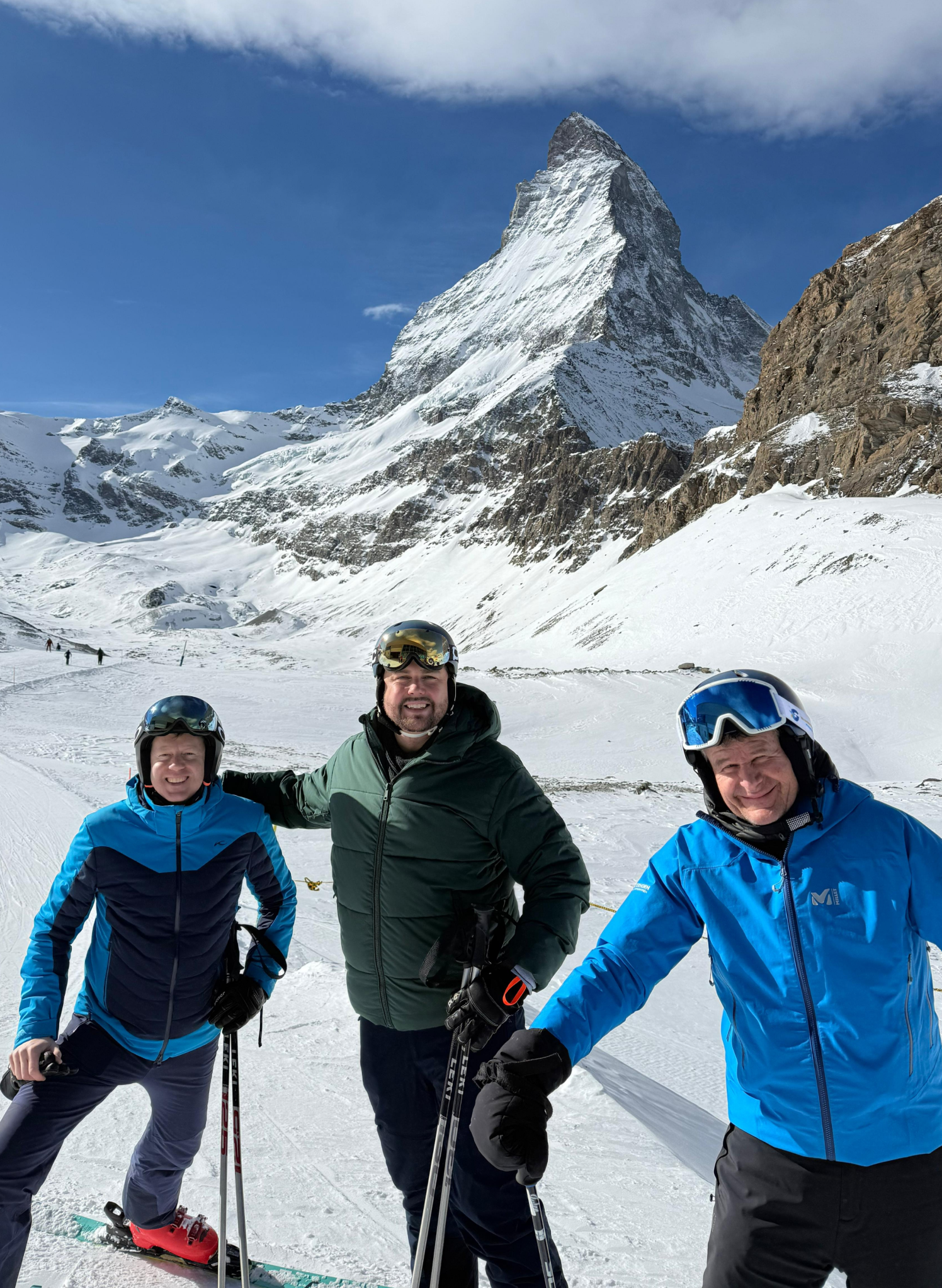 checkyeti's CEO Jakob Keller and CFO Georg Reich with a ski instructor on the slopes in Zermatt, Switzerland, with the Matterhorn visible in the background.