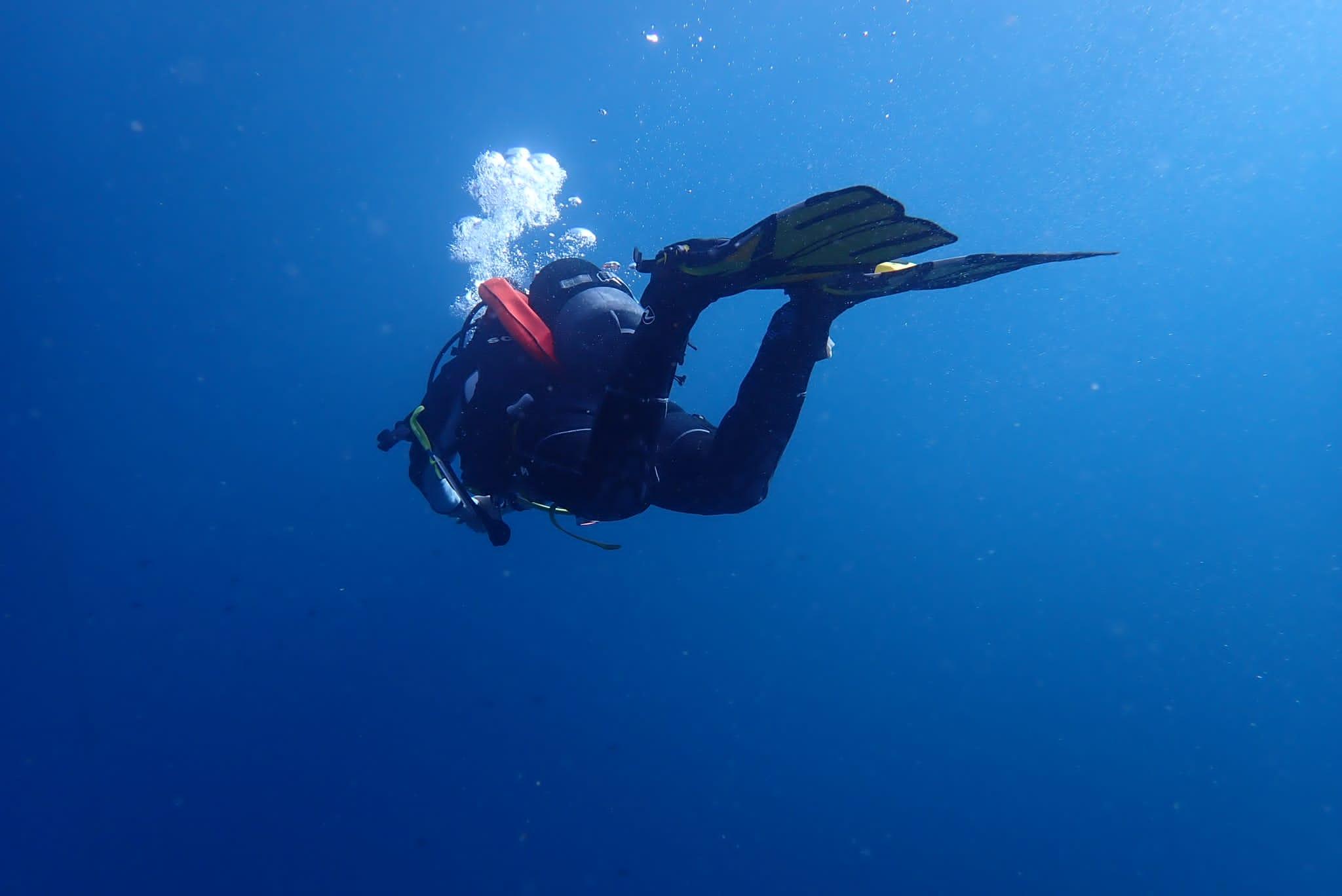 Un buceador con botella de oxígeno y equipo de buceo proporcionados por el Centro de Buceo Figarolo Golfo Aranci.