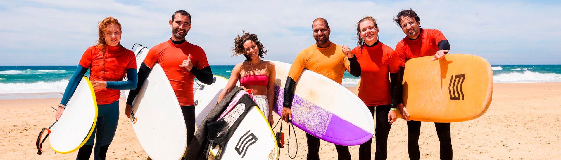 Die Surflehrer von SeaKrew Ericeira posieren gemeinsam gut gelaunt für ein Foto