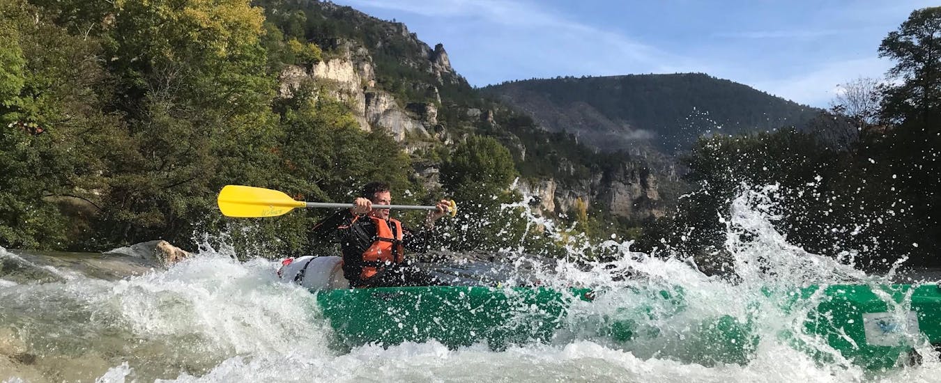 A young man is paddling activly in the heart of the Gorges during the Canoe Rental on the Tarn with Canoe La Cazelle Gorges du Tarn.