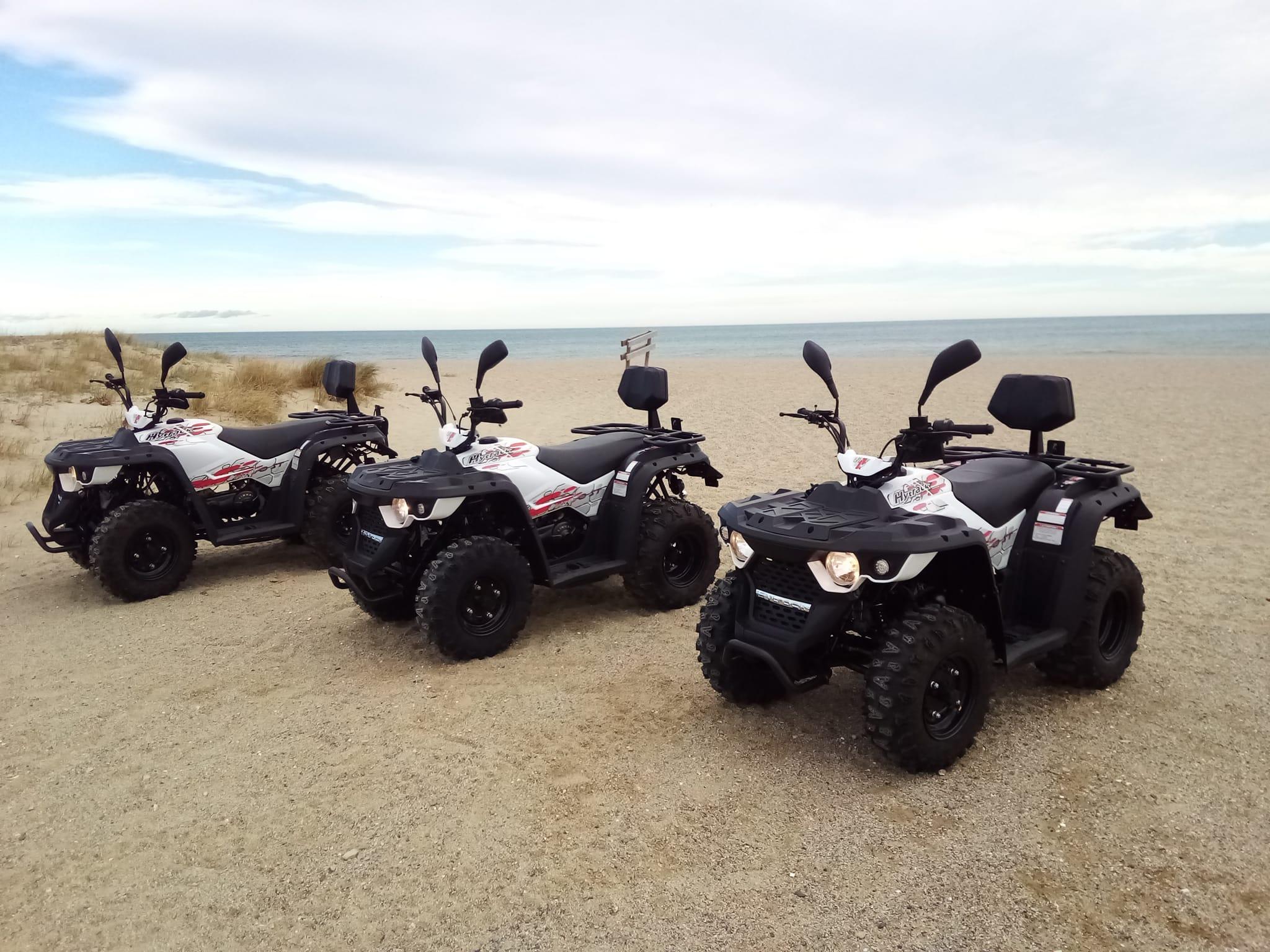 Drei Quads von Randoquad 66, die am Strand von Barcarès aufgereiht sind.