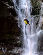 Mann beim Canyoning in einem Wasserfall am Fluss Savinja.