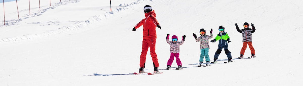Nouvelles régions SEM Hero 1 Moniteur de ski et enfants dévalant les pistes pendant une leçon de ski.