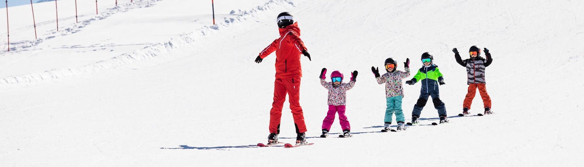 Ski instructor and kids enjoy a ski lesson with a ski school near Bichlbach.