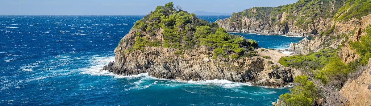Boat Trips to Porquerolles SEM Hero Die Steilküste von Porquerolles von der Küste aus gesehen während einer Bootsfahrt.