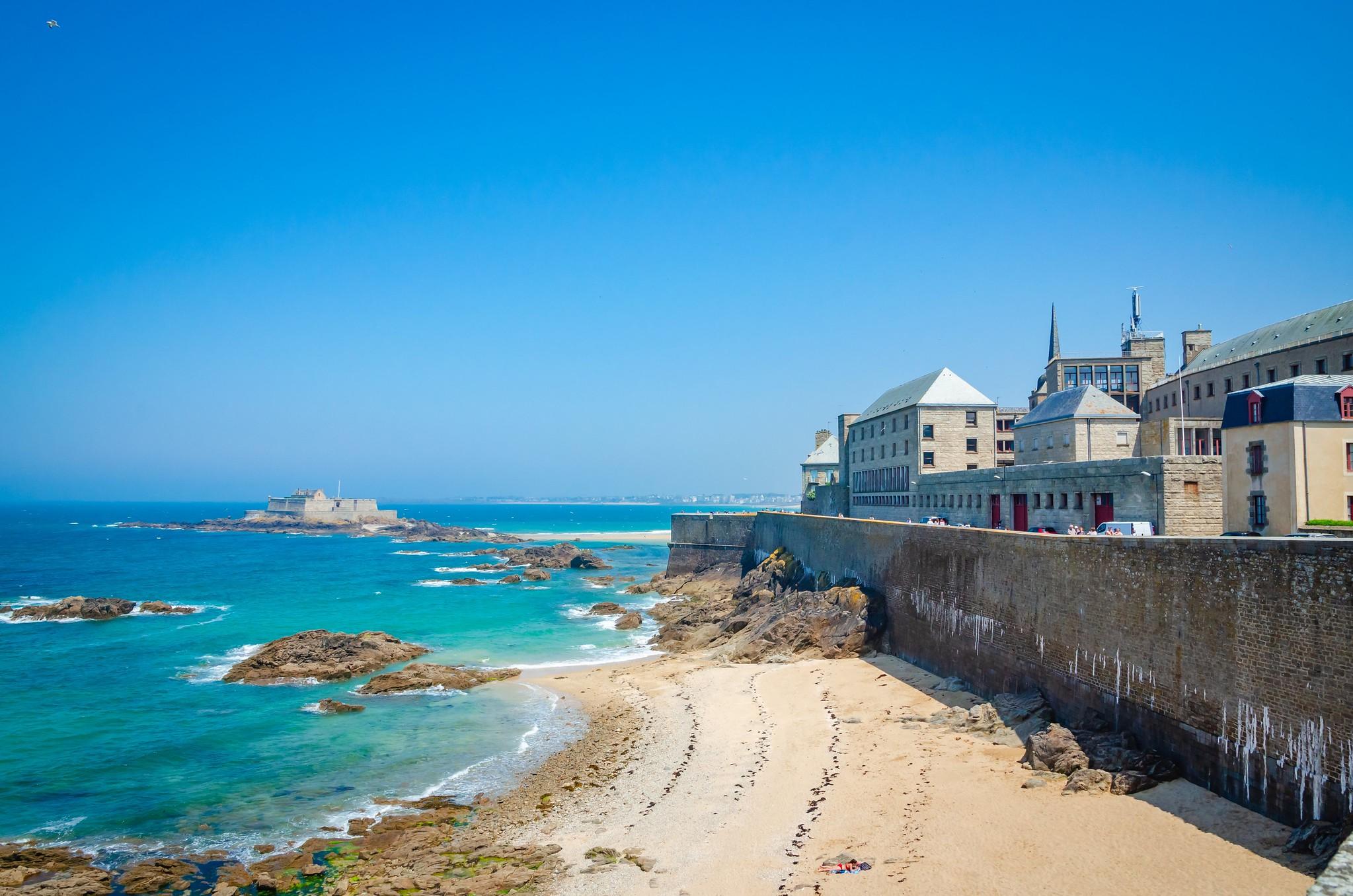Vue de Saint-Malo, en Bretagne, avec la mer au premier plan et la ville historique en arrière-plan.