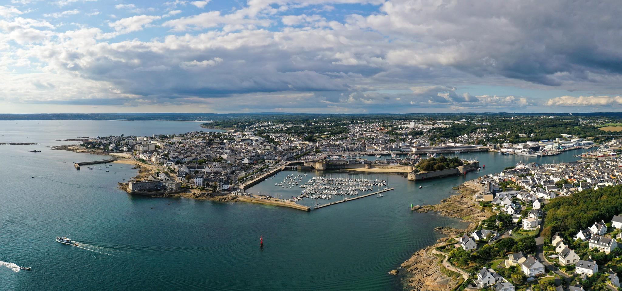 Vue du port de Concarneau avec des bateaux amarrés sur une eau calme.
