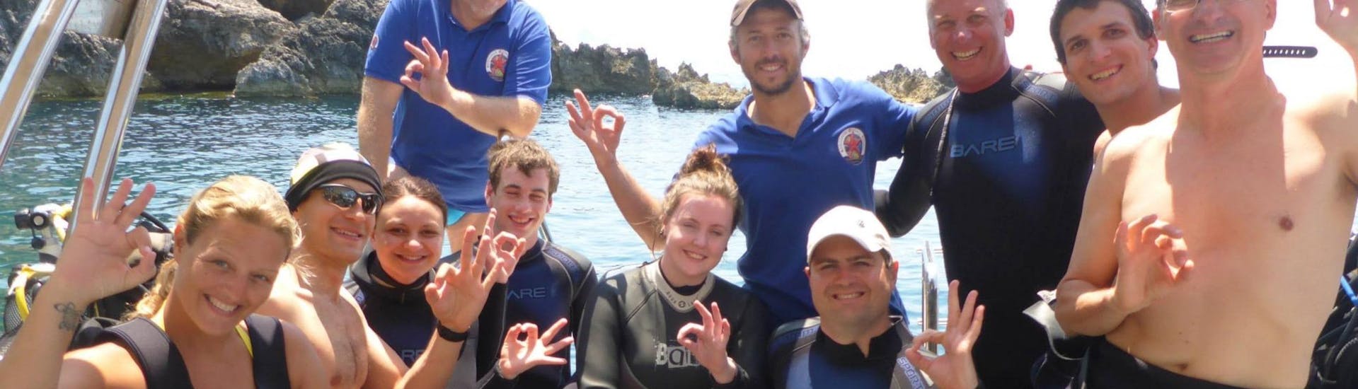 Eine Gruppe Taucher lächelt bei einer Tauchexkursion von Achilleon Diving Center Korfu für ein Gruppenfoto in die Kamera.