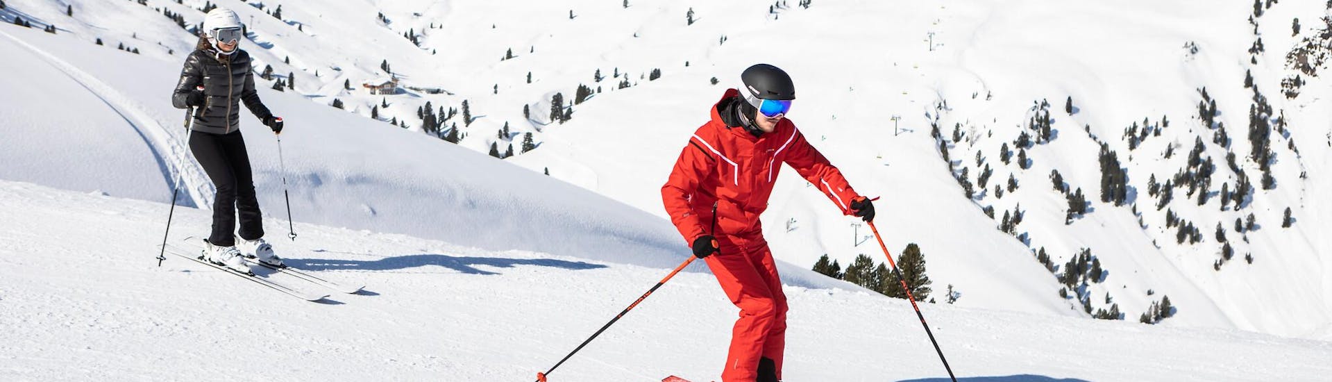 Un adulto con su profesor de esqui durante una clase de esqui para adultos.
