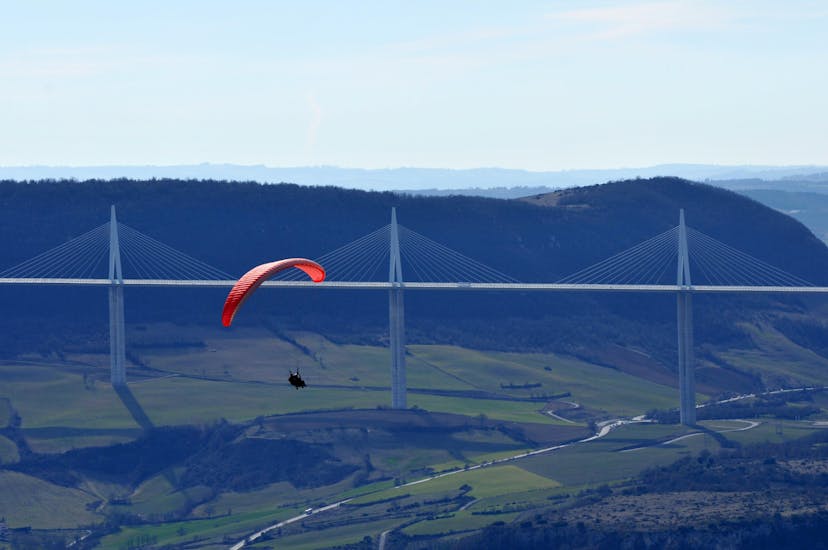 Un pilote de parapente d'Air Magic Parapente effectue un vol en tandem en parapente devant le viaduc de Millau.