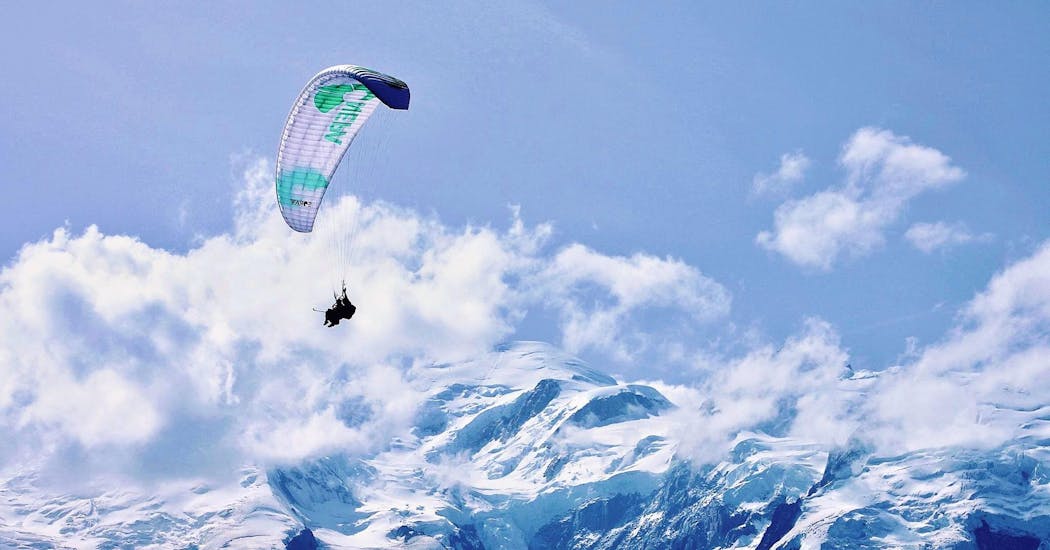 A paragliding pilot from Air Sports Chamonix is doing a paragliding flight above the Alps.