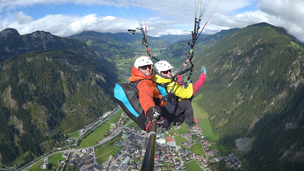 A participant and his tandem pilot enjoy the view during a paragliding flight with AIRflow Tandem Paragliding Zillertal.
