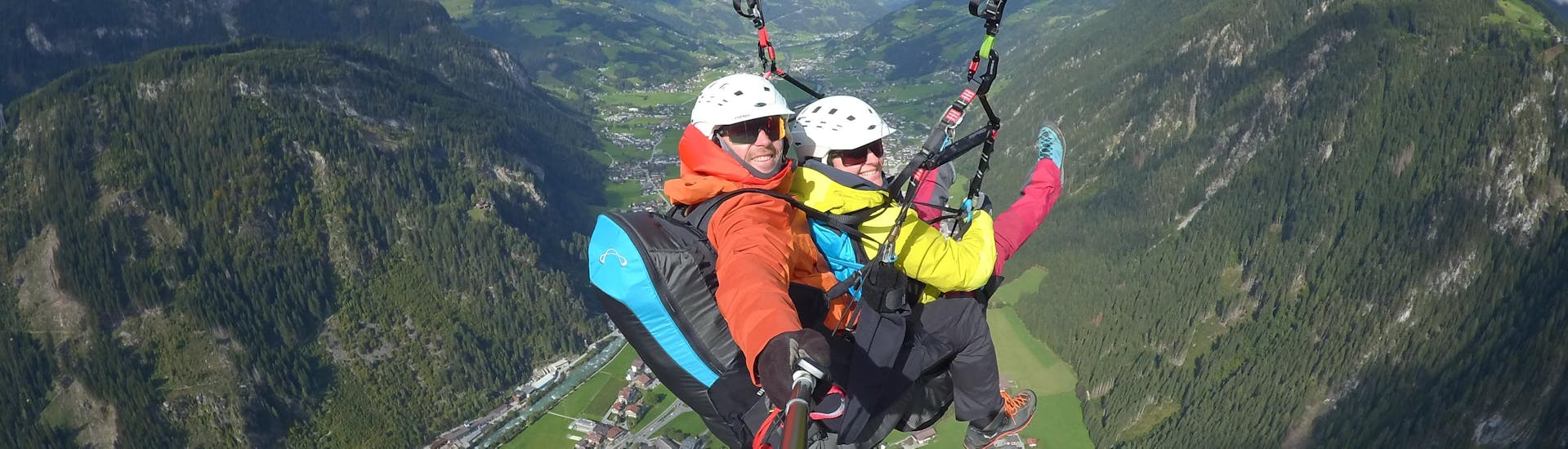 Ein Teilnehmer und sein Tandempilot genießen den Ausblick bei einem Paraglidingflug mit AIRflow Tandem Paragliding Zillertal.