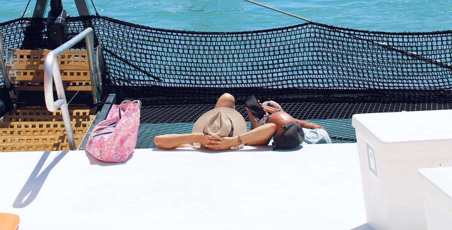 Una pareja se relaja en el catamarán de Albarco Cruceros Sancti Petri.