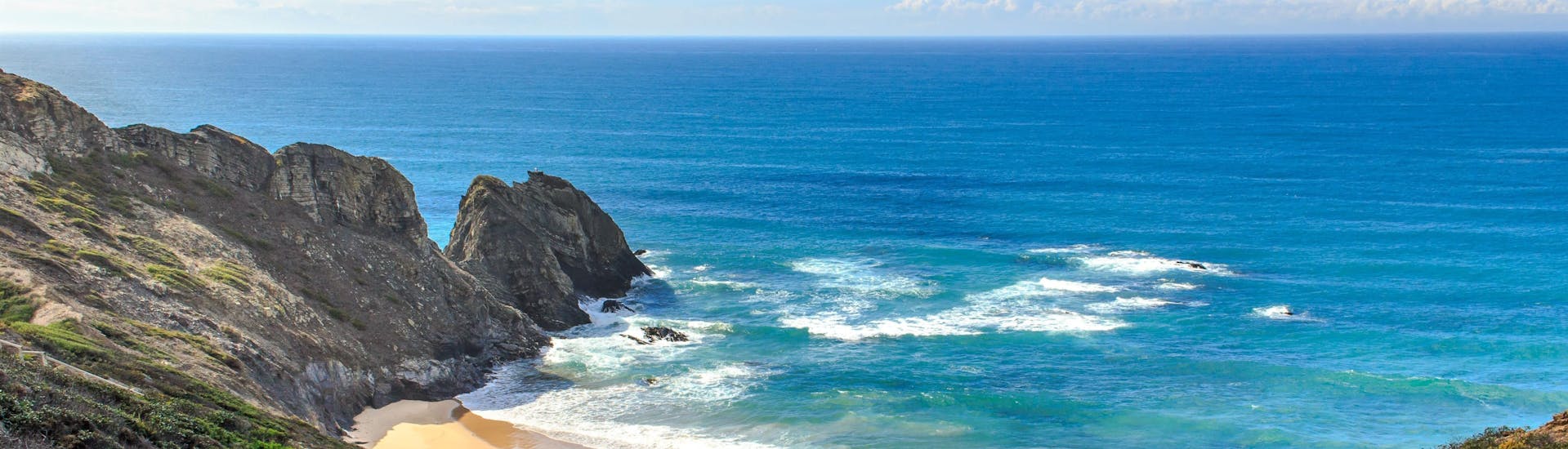 Un parapentiste est émerveillé par le paysage lors d'un vol en parapente biplace dans la célèbre destination de parapente Praia da Cordoama.