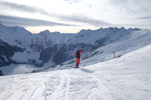 Adultos y niños esquiando en la estación de esquí de Alpbach.