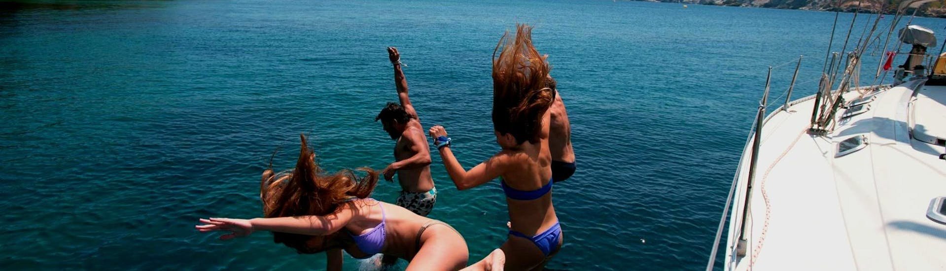 Eine Gruppe von Freunden, die während einer Bootstour von Heraklion nach Dia vom Boot von Altersail springen.