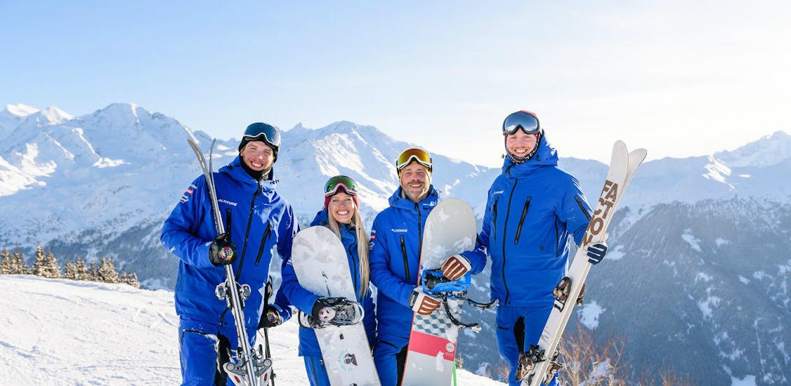 The ski and snowboard instructors of Altitude Ski School Zermatt are posing for a group photo with their equipment.