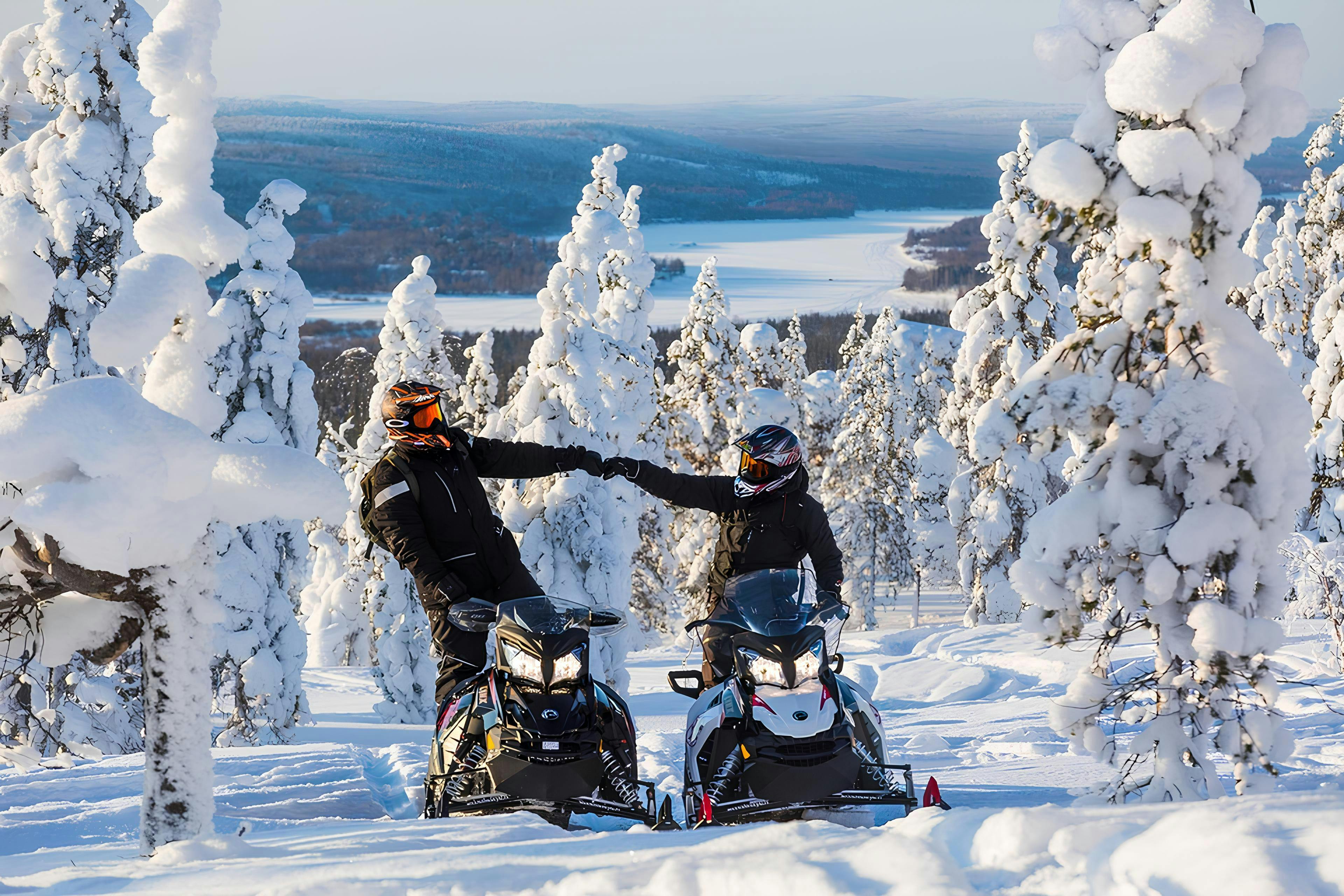 Arctic Lifestyle Dos personas disfrutan de un día soleado y conducen sus motonieves.