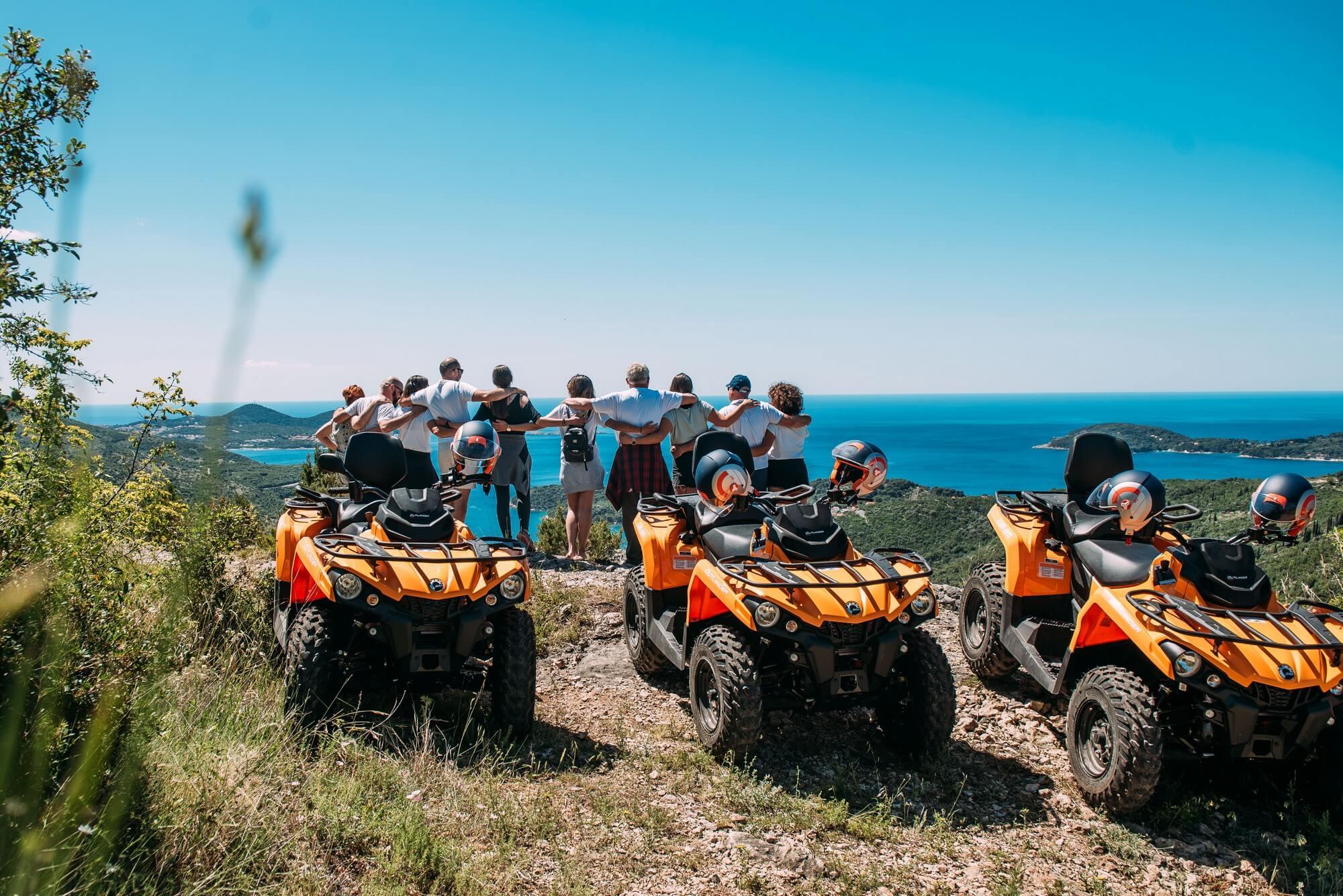 Group of people standing on a viewpoint, overseeing the Croatian coastline.