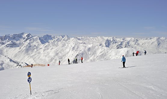 Adults and kids skiing in Axamer Lizum ski resort.