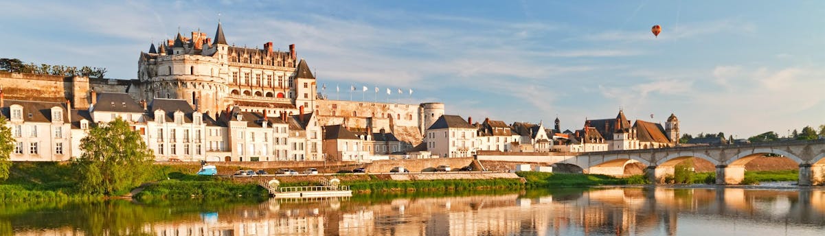 ballooning-chateaux-near-paris_SEM-Resort-Hero A hot-air balloon is flying over one of the Loire Valley castles near Paris, a popular destination for ballooning in France.