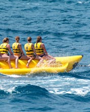 A group of friends goes on a banana boat ride in St George's Bay with Sun & Fun Watersports.