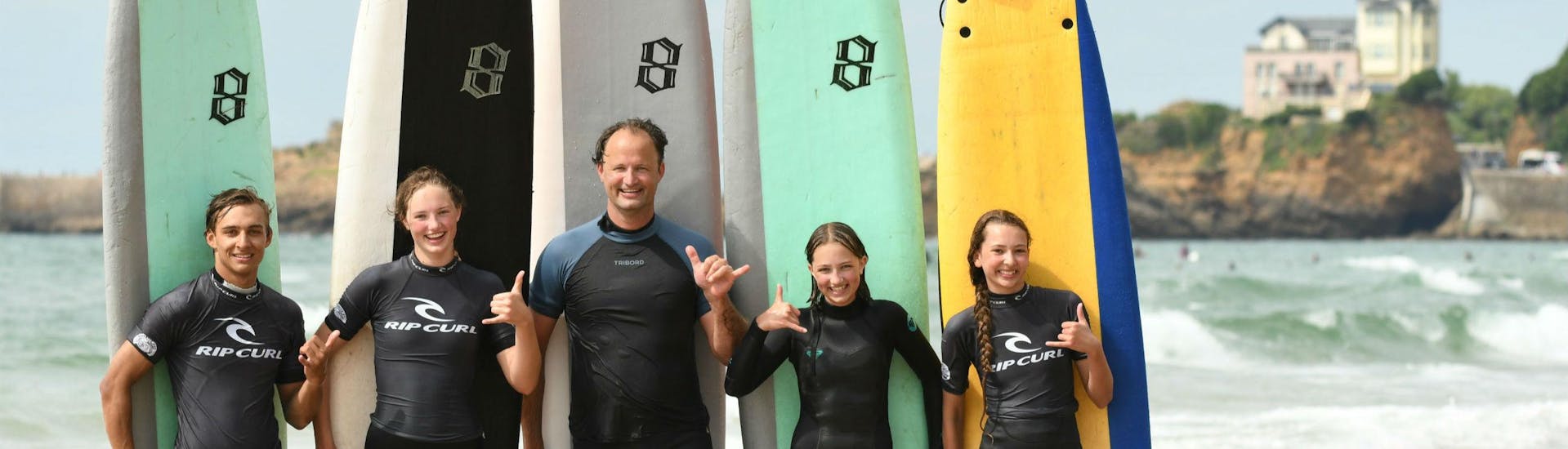 A group of people is having Surfing Lessons on the Marbella Beach with their surfing instructor from the Eco surf school in Biarritz.