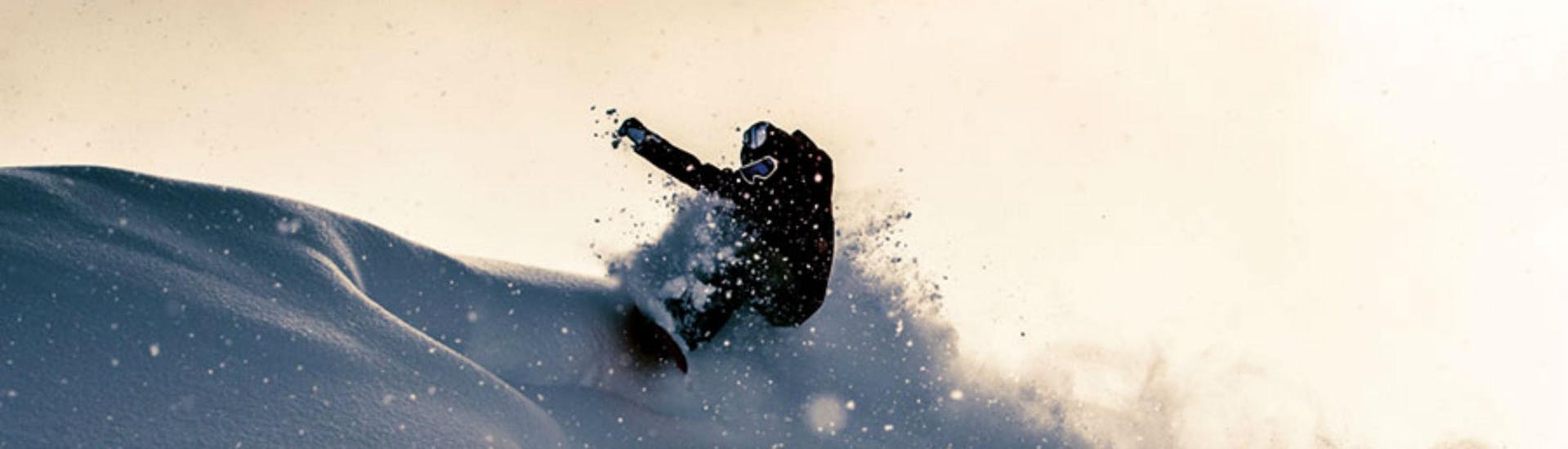 Ein Snowboardlehrer von Board.at mach spektakuläre Freestyle Tricks im Tiefschnee,