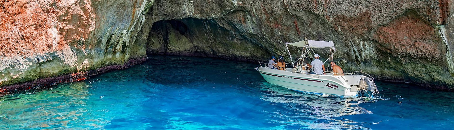 Group of people heading into a sea cave enjoy a boat rental activity where no license is needed