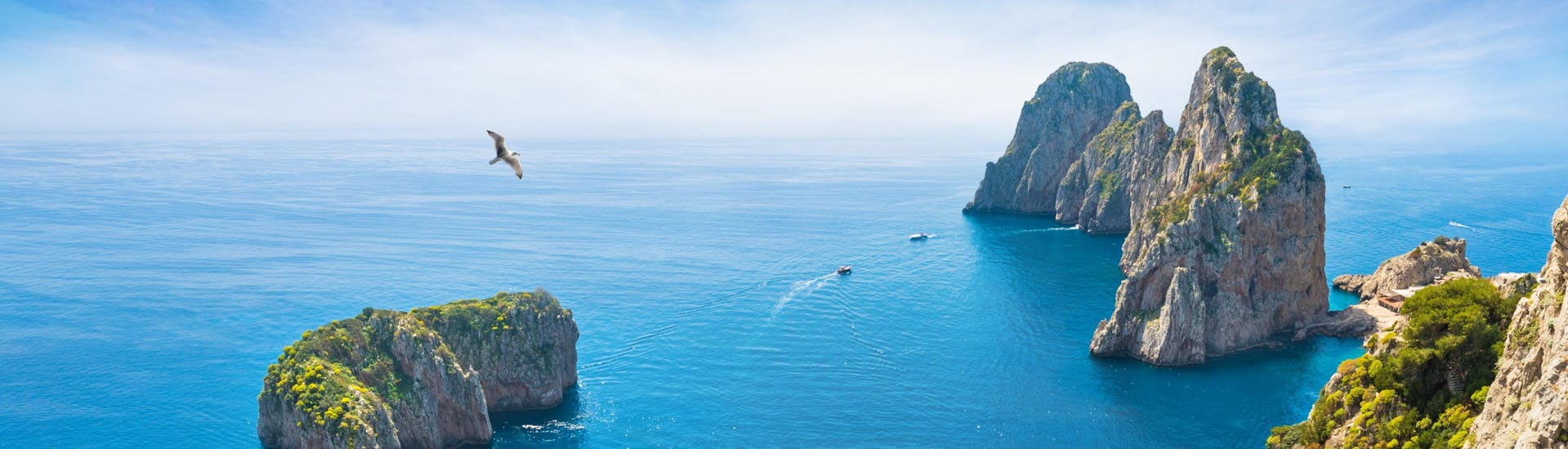 View of the Faraglioni di Capri during the summer with a blue and sunny sky. 