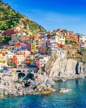 An image of the picturesque little village of Manarola perched on top of the cliffs, one of the sights afforded to those who go on a boat trip along the Cinque Terre coast.