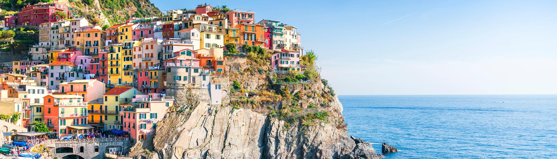 An image of the picturesque little village of Manarola perched on top of the cliffs, one of the sights afforded to those who go on a boat trip along the Cinque Terre coast.