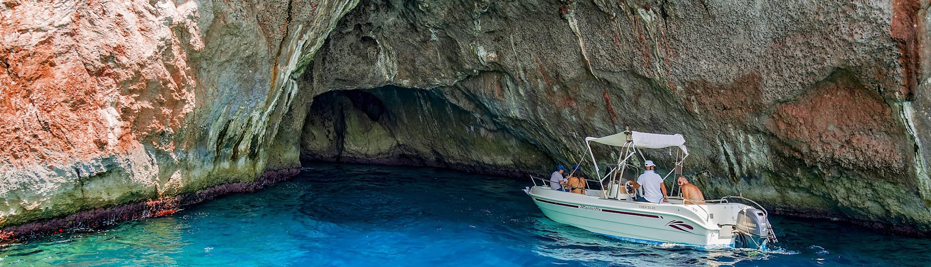 Eine Freundesgruppe macht eine Bootstour in der Urlaubsregion Blaue Grotte.