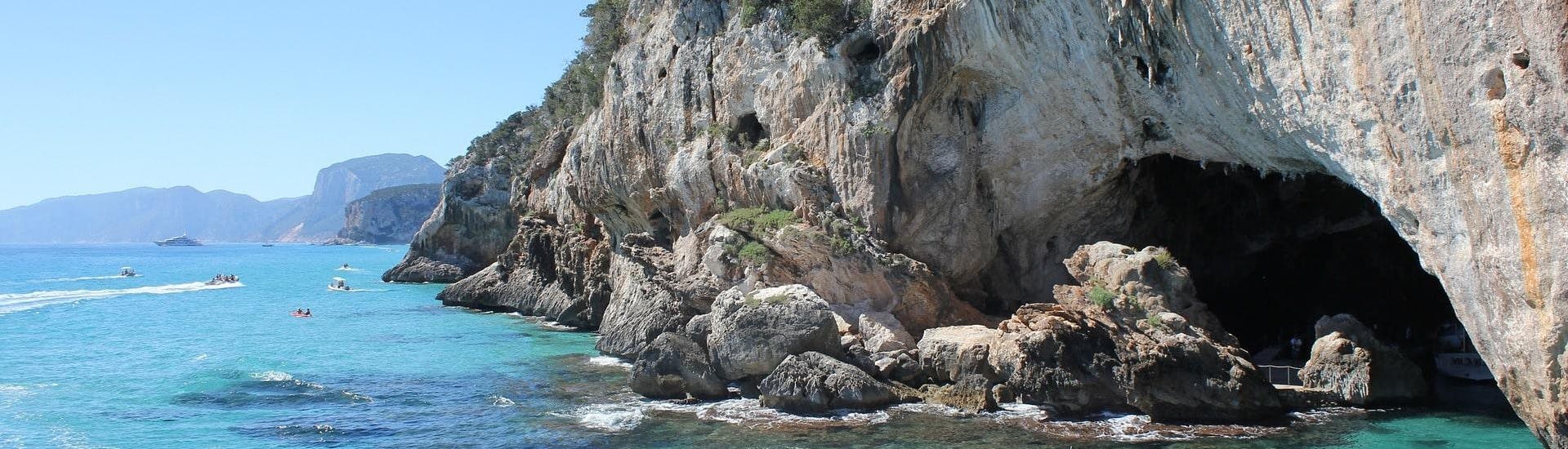 Ein Boot kommt aus der Grotta del Bue Marino, die man bei einer Bootstour in Sardinien besichtigen kann.