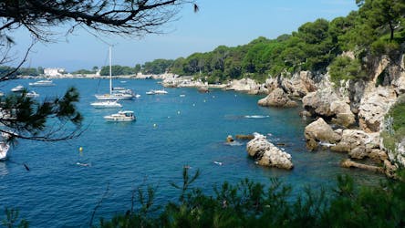Boats are anchored in a quiet bay of Cap d'Antibes which can be admired during a boat trip from Juan-les-Pins.