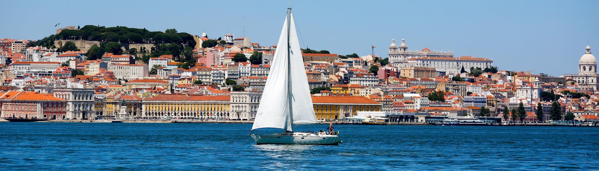 Ein Bild eines Segelboots, das während einer Bootsfahrt in Lissabon auf dem Tejo treibt.