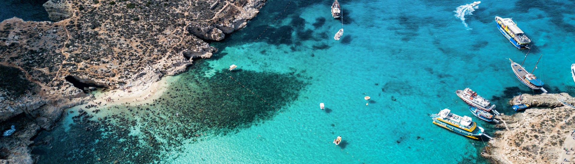 Top view of boats gathering in the Blue Lagoon, Malta,  a popular destination for boat tours.