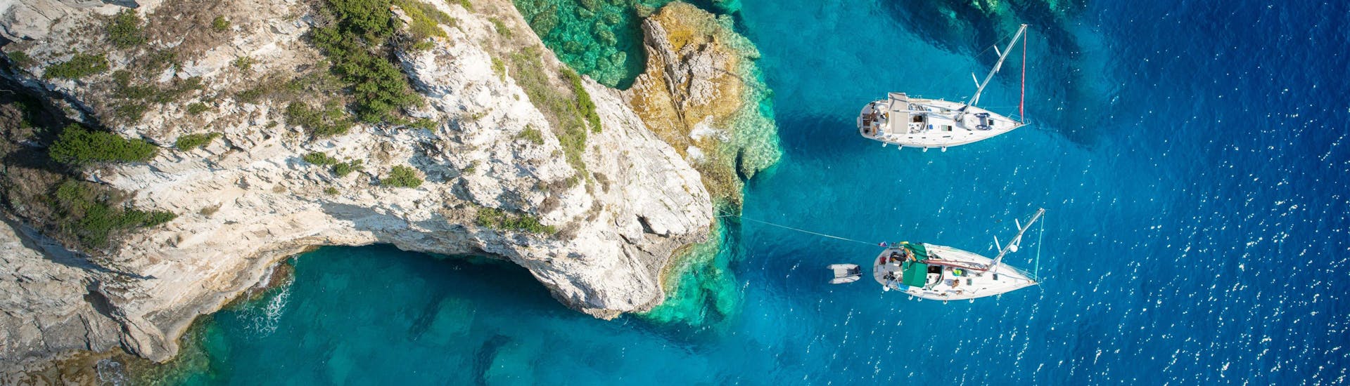 Aerial view of a cove on the island of Paxos where boats are moored, a popular destination in Greece for boat trips.