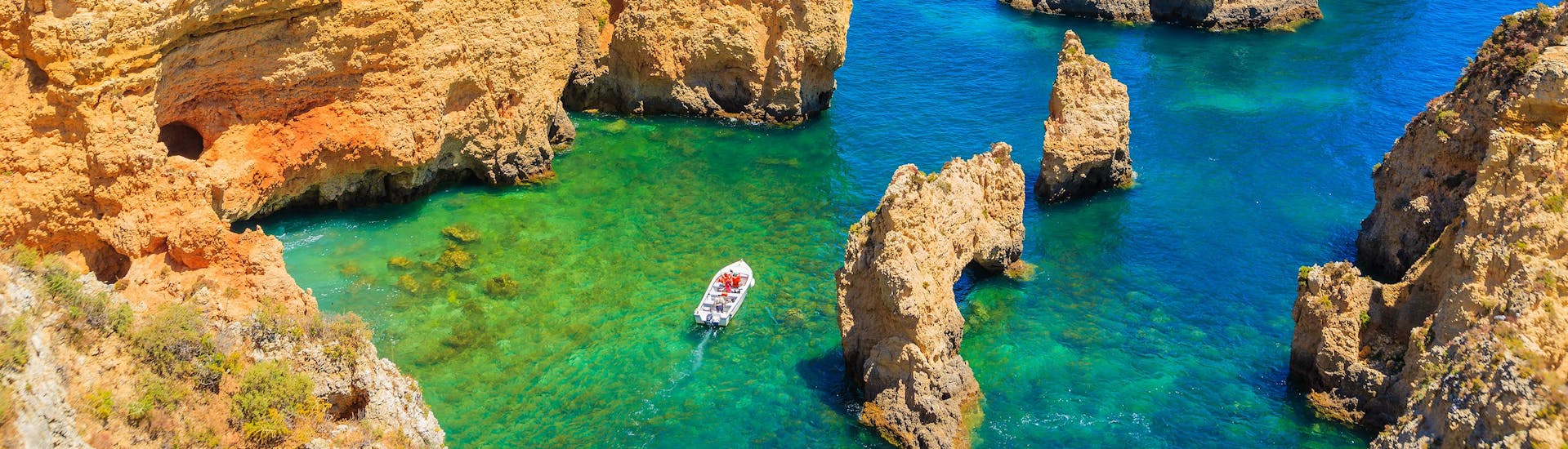 A view of the famous rocks of Ponta da Piedade in Portugal with a number of boat trip operators navigating their boats along the coast.