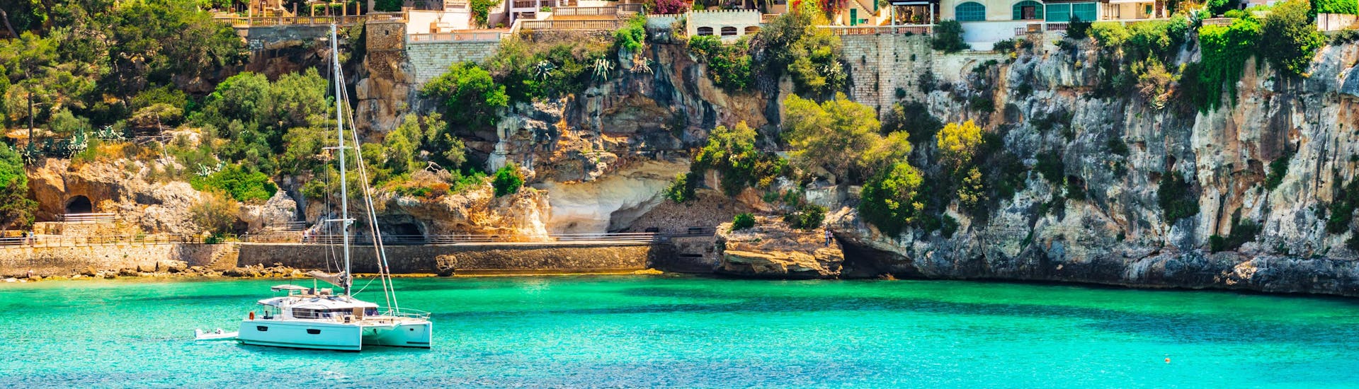 Ein Katamaran in der Bucht von Monte Cristo, die ein beliebter Ausgangspunkt für Bootstouren entlang der Ostküste Mallorcas ist.