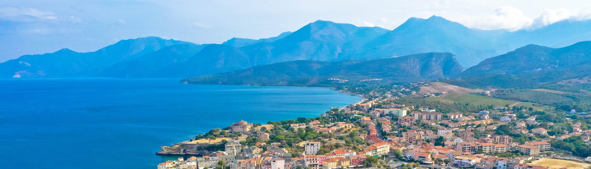 Luftaufnahme des Hafens von Saint-Florent im Norden Korsikas, wo viele Bootstouren zum Cap Corse starten.