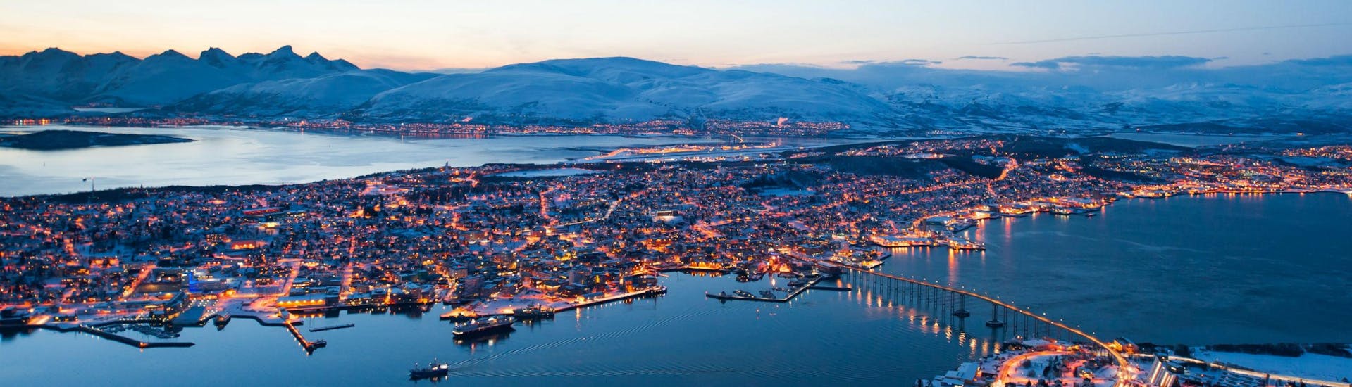 A view of Norway's Arctic Capital Tromsø at sunset, where several operators offer a range of boat trips for visitors to go whale watching, see the fjords or catch a glimpse of the northern lights.