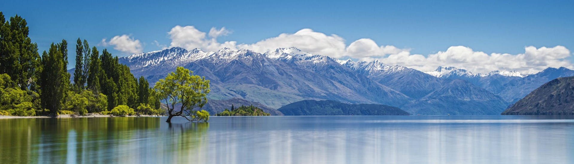A view of the calm and peaceful waters of Lake Wanaka and the stunning scenery around it, as can be seen on a boat trip in Wanaka.