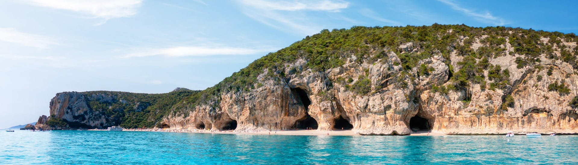 Photo des grottes situées le long de la côte de Cala Luna, en Sardaigne, une destination populaire pour les excursions en bateau.