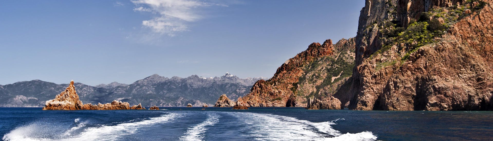 Vue de l'arrière d'un bateau lors d'une balade en bateau de Sagone aux impressionnantes Calanques de Piana, sur la côte ouest de la Corse.