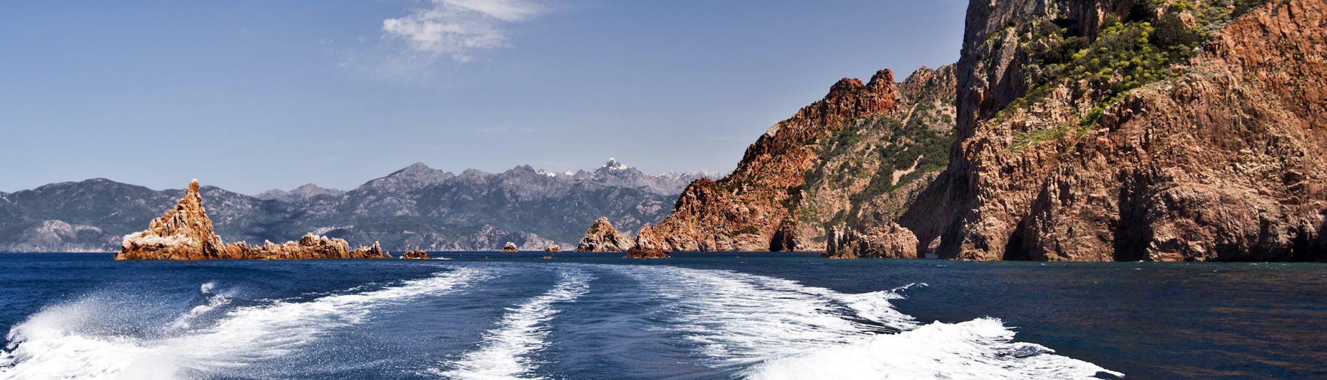 Blick vom Heck eines Bootes während einer Bootstour in den beeindruckenden Calanques de Piana an der Westküste Korsikas.