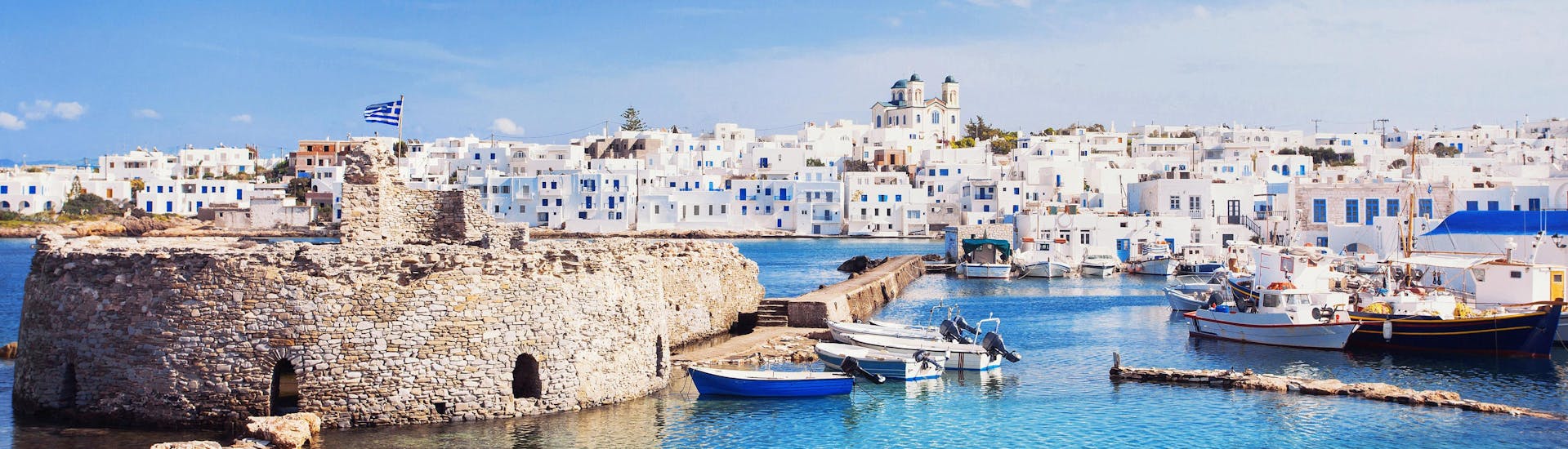 Beautiful view of the characteristic white houses lining the coasts of Cyclades, Greece, a popular destination for boat trips.