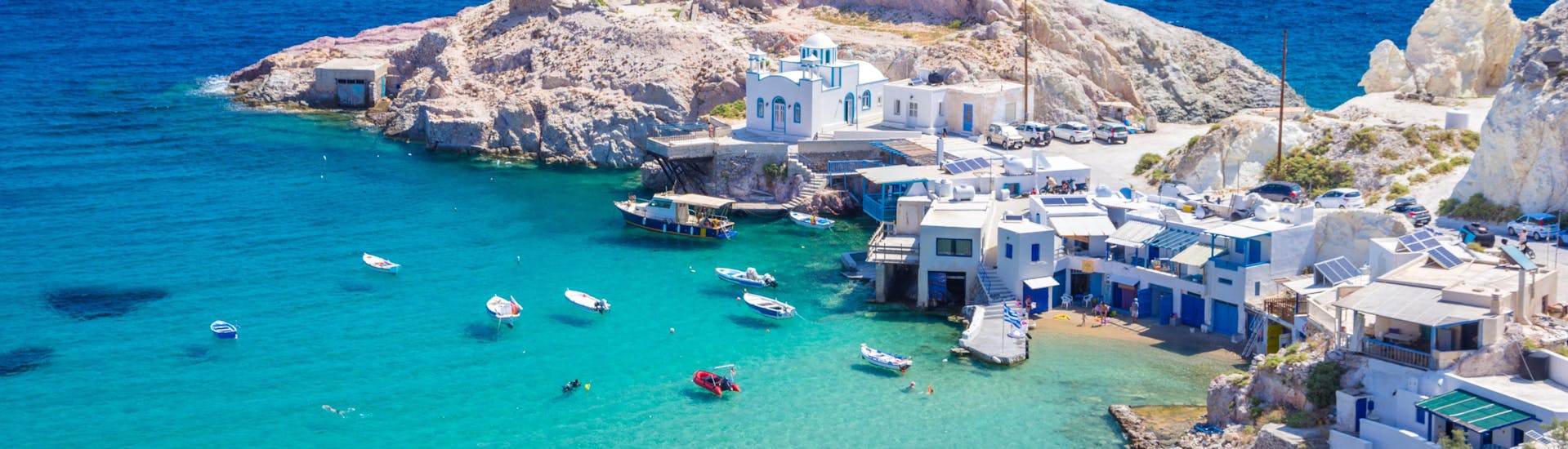 Beautiful view of Milos island during the summer with clear waters where boat trips providers anchor for swimming.