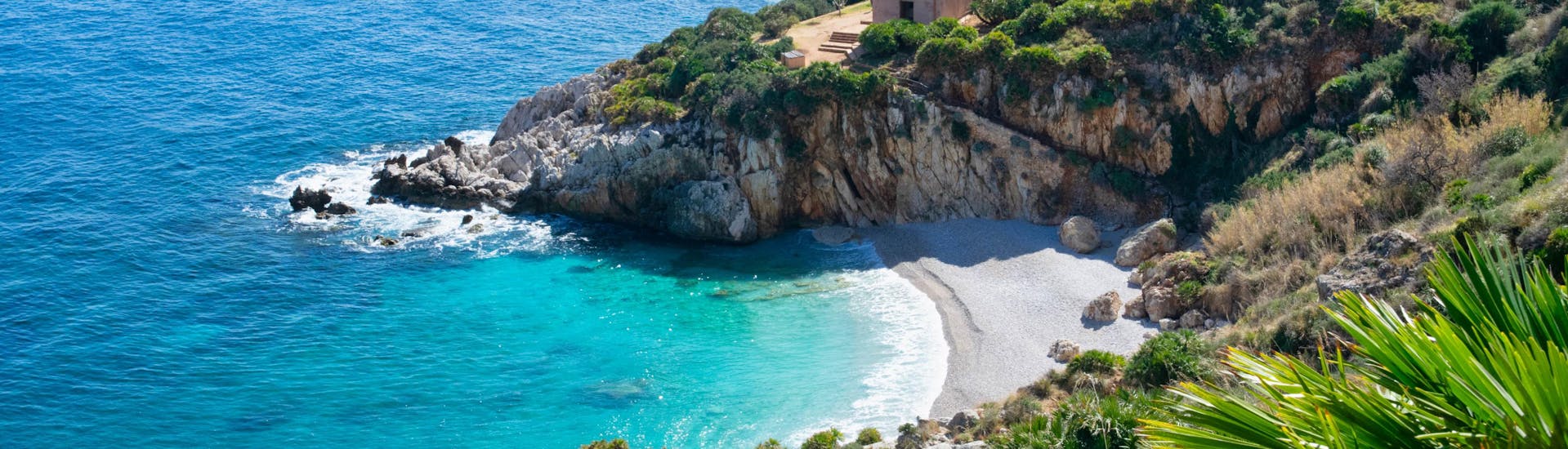 View of the Cala dell'Uzzo, a beautiful beach that you can see on a boat trip to the Riserva Naturale dello Zingaro.